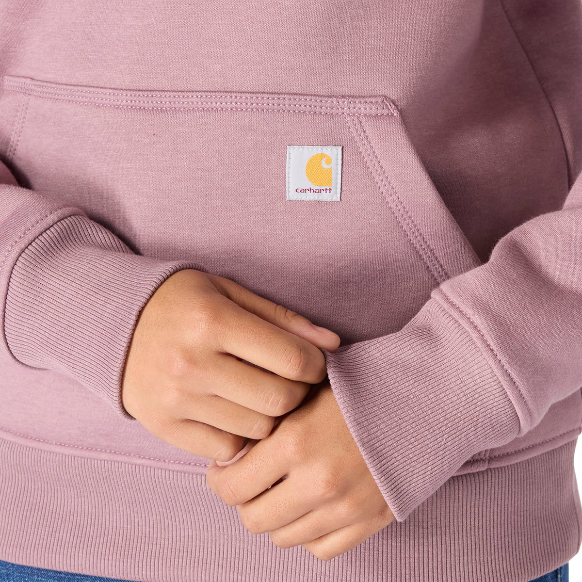Person wearing a pink hoodie with Carhartt logo on chest pocket