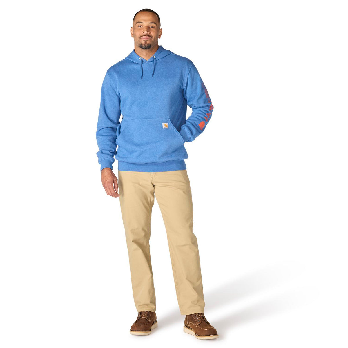 Man wearing a blue hoodie and beige pants on a white background