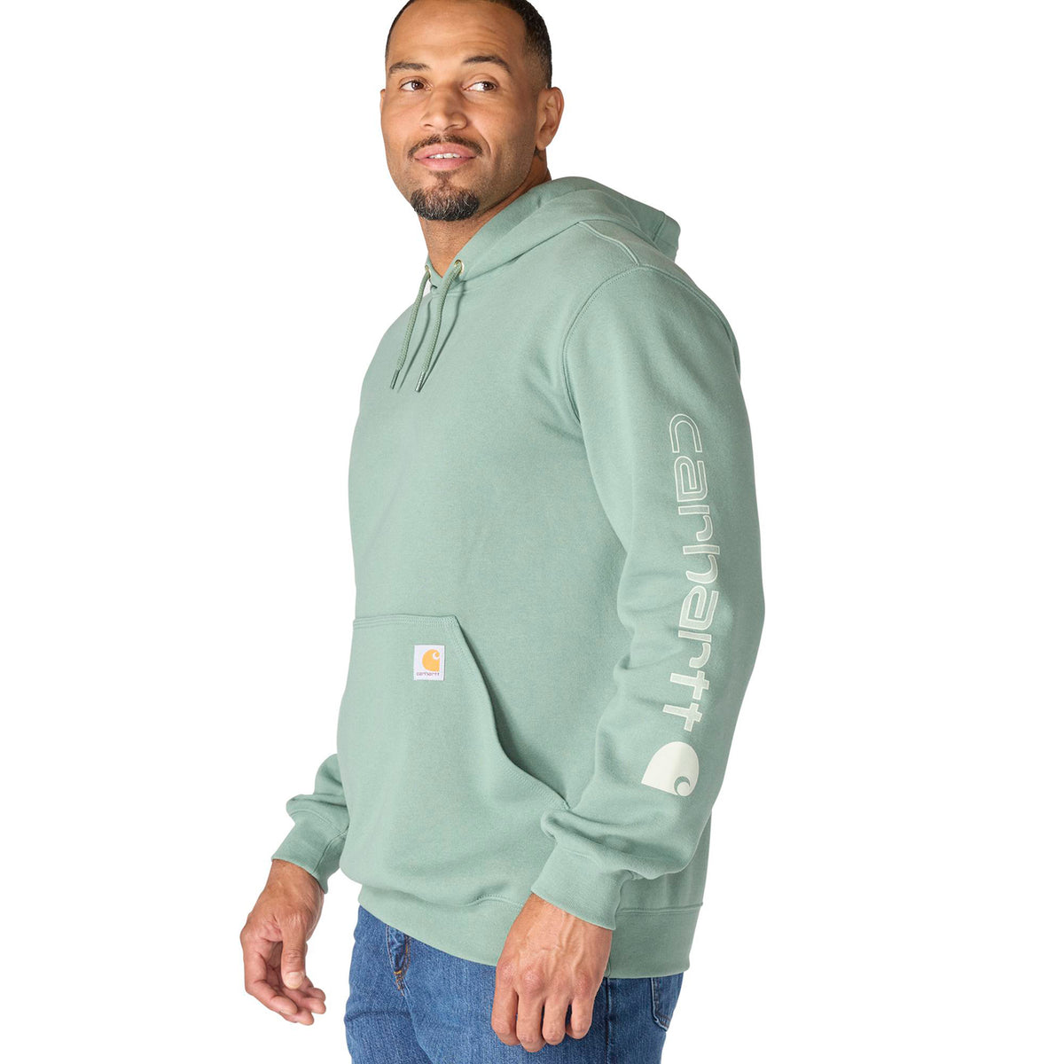 Man wearing a light green hoodie with Carhartt logo on a white background